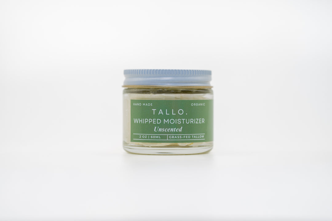 A closed 2 oz glass jar of Tallo Unscented Whipped Moisturizer. The jar describes the size, ingredients, and handmade nature of the skincare.