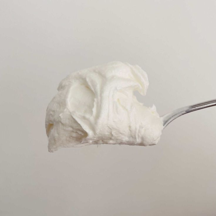 Whipped beef tallow turned into whipped moisturizer being held by a silver spoon. Made from grass-fed tallow.