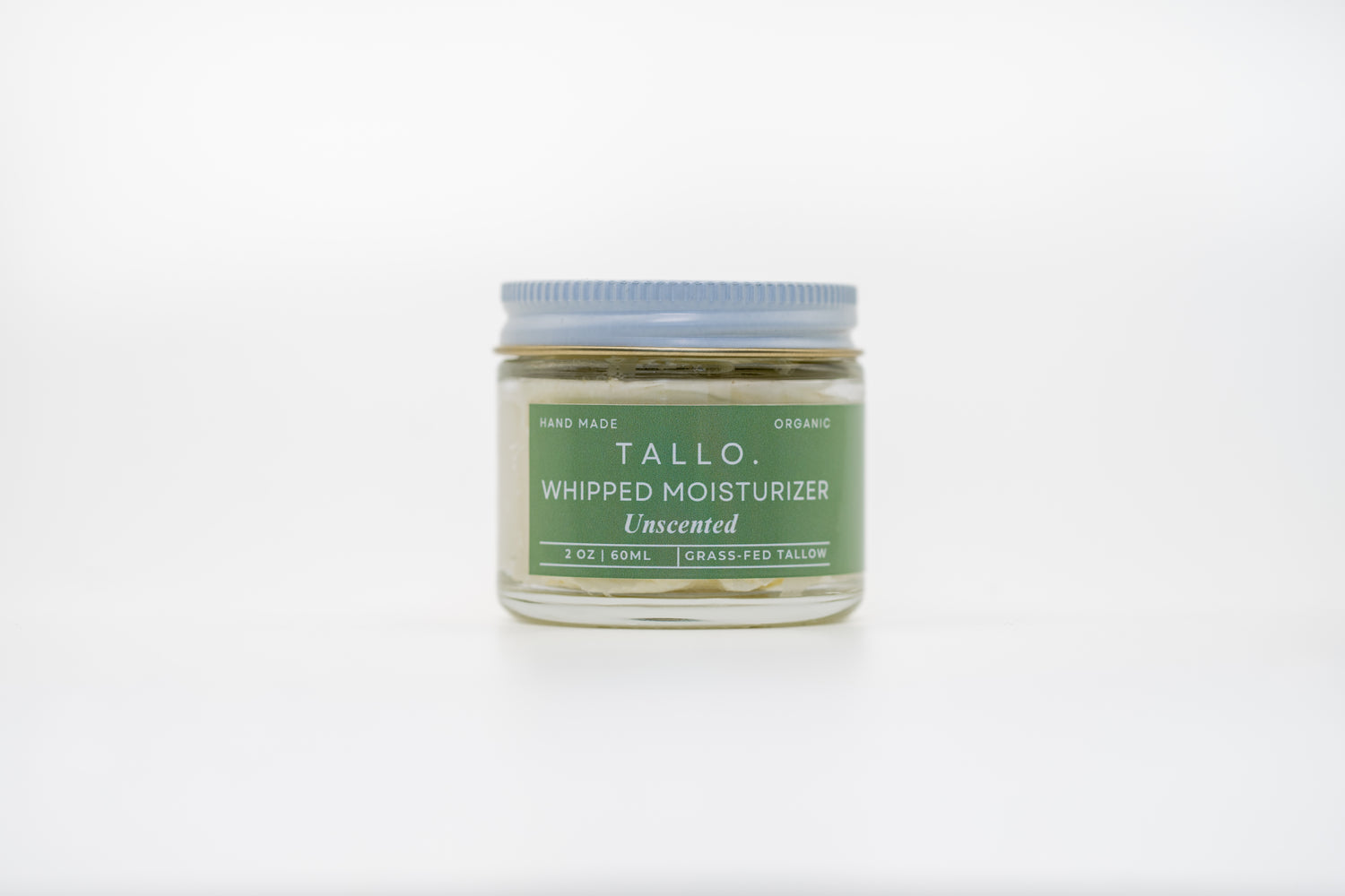 A closed 2 oz glass jar of Tallo Unscented Whipped Moisturizer. The jar describes the size, ingredients, and handmade nature of the skincare.